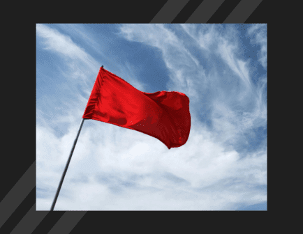 Red flag waving against blue sky